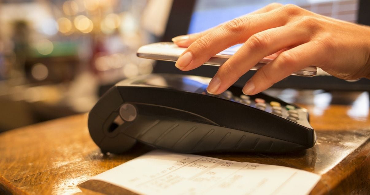 Manos de mujer joven adulta en el escritorio de la recepcion haciendo check in y abonando con tarjeta de credito que hasta ahora es la forma de pago en hoteles mas extendida